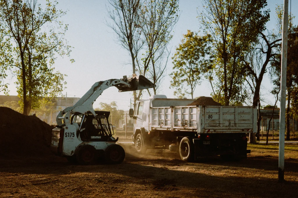 Skid steer loading material onto a truck at a job site